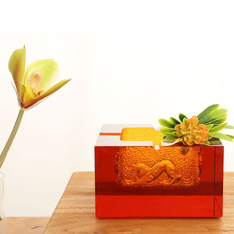 Rødt glasaskebæger med udsøgte prægede dyremønstre